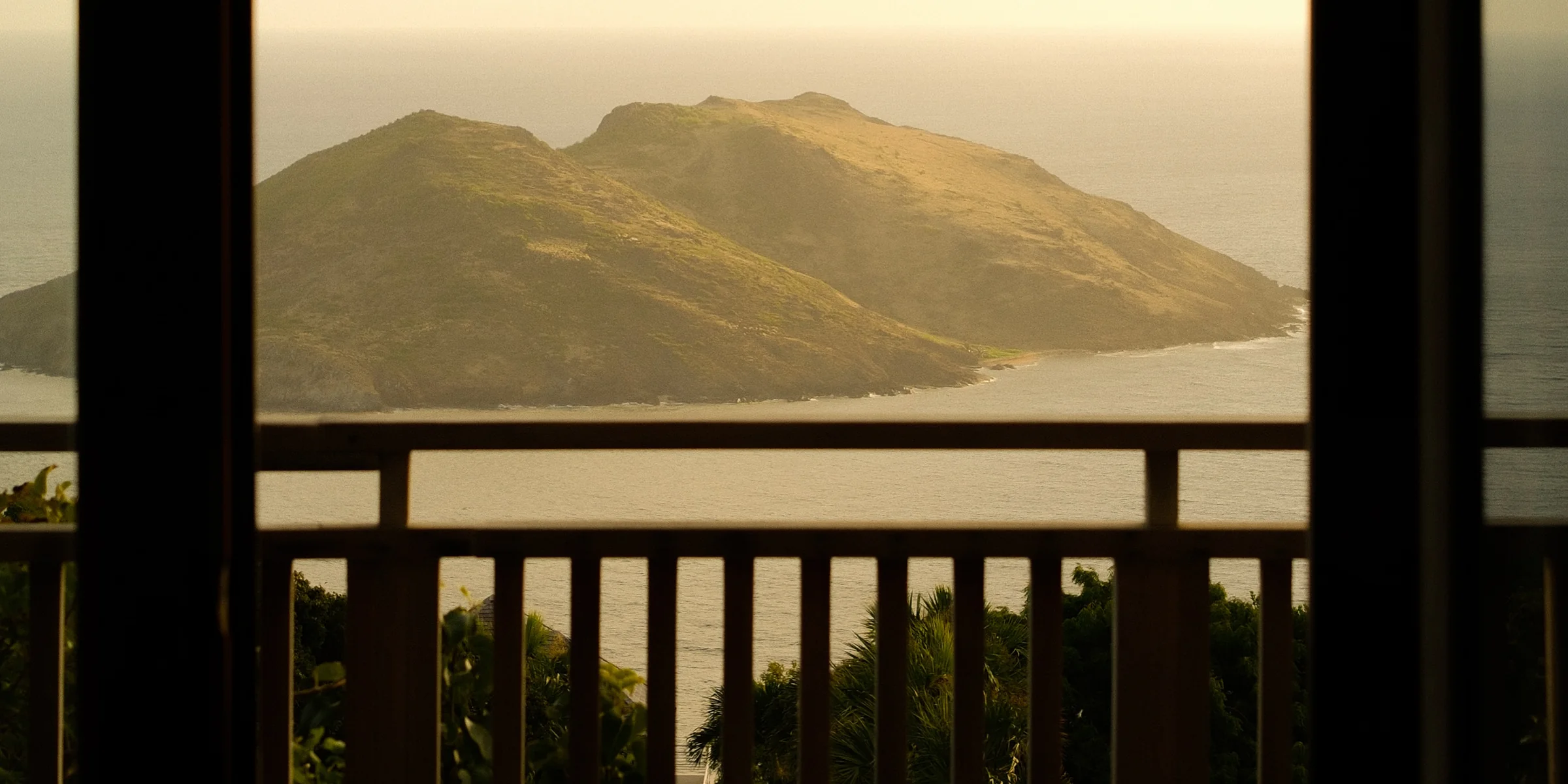 An island off St Barths at dusk, seen from a balcony.